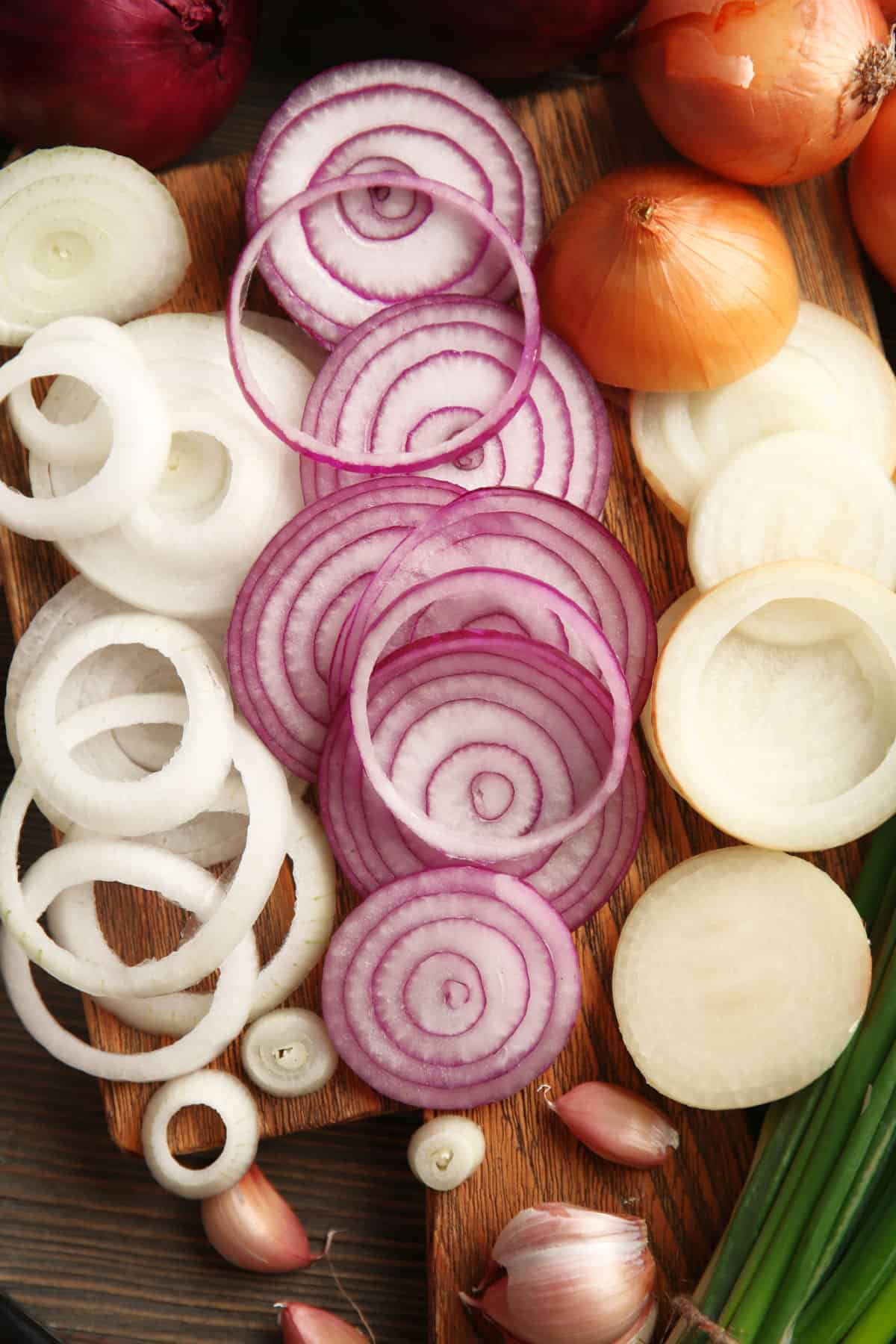 Sliced onions spread out on a board.