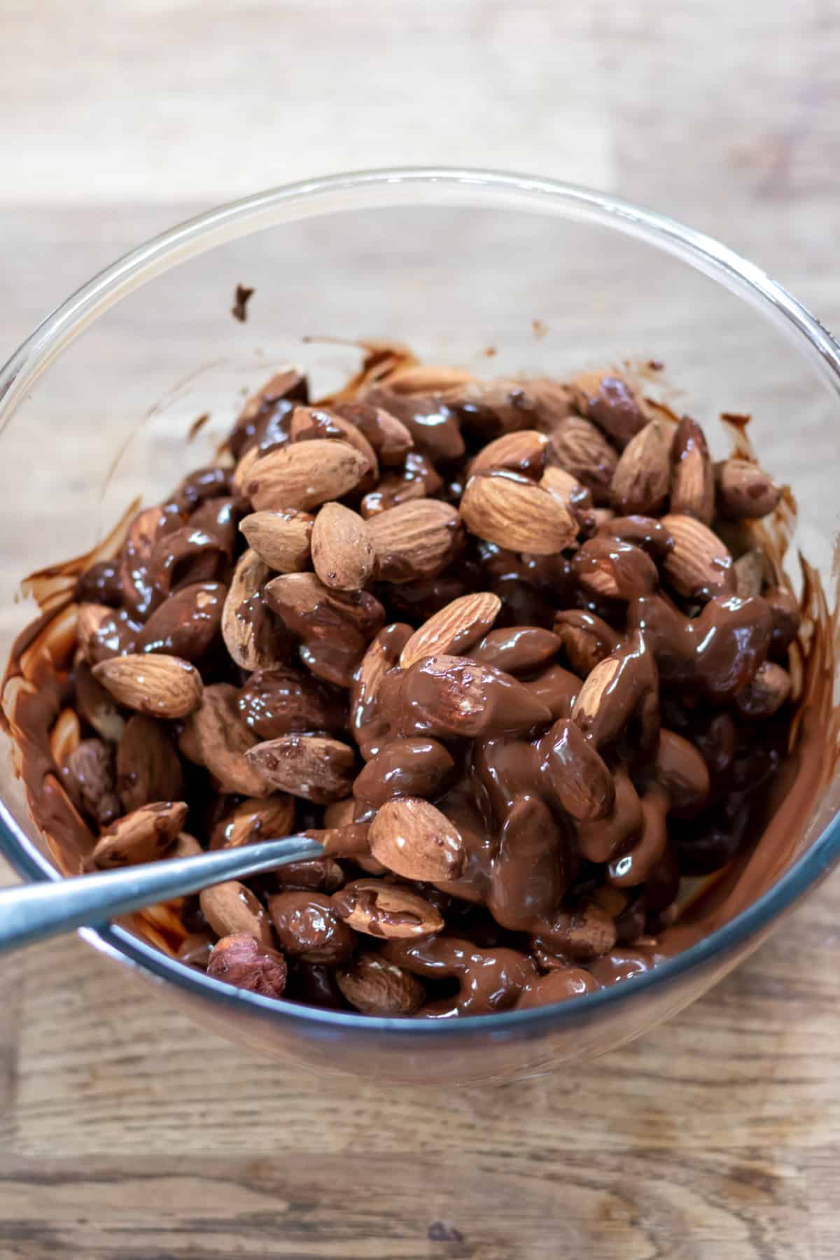 Stirring almonds into the melted chocolate.