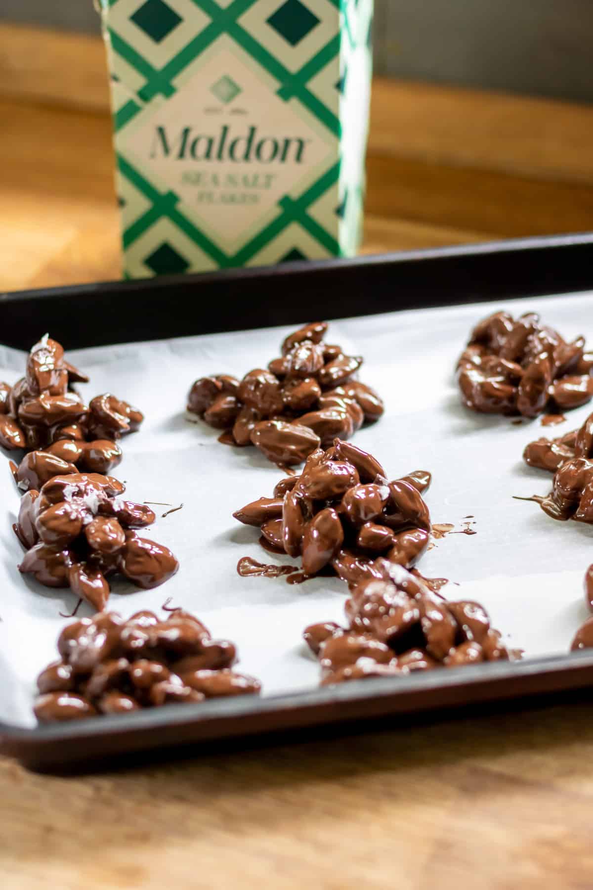 Adding sea salt to the chocolate almond clusters.