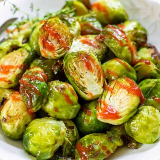 Close up of roasted brussels sprouts with honey and sriracha.