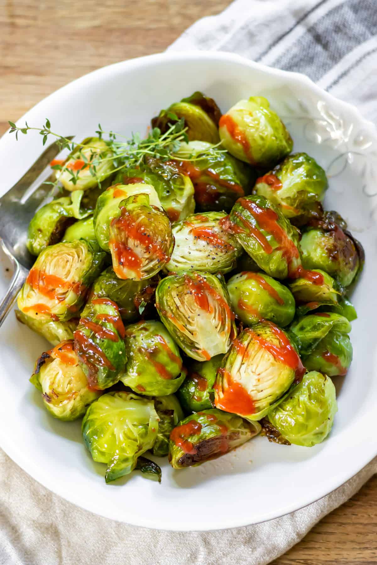 Plate of roasted brussels sprouts with honey sriracha glaze.