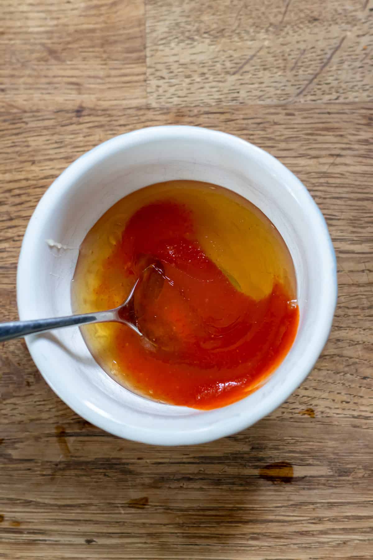 Mixing honey and sriracha in a bowl.
