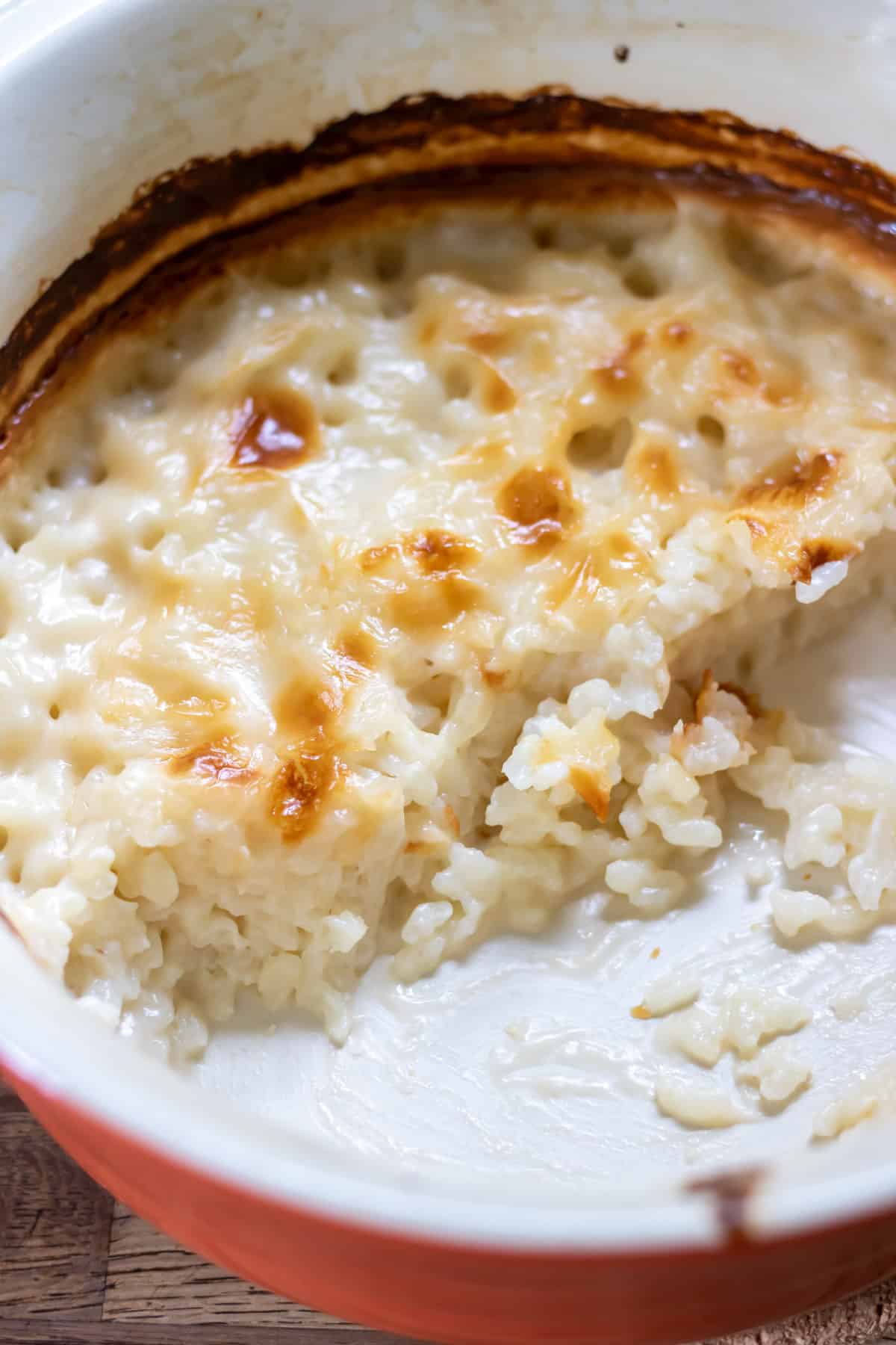 Dish of baked vegan rice pudding with some out of the dish.