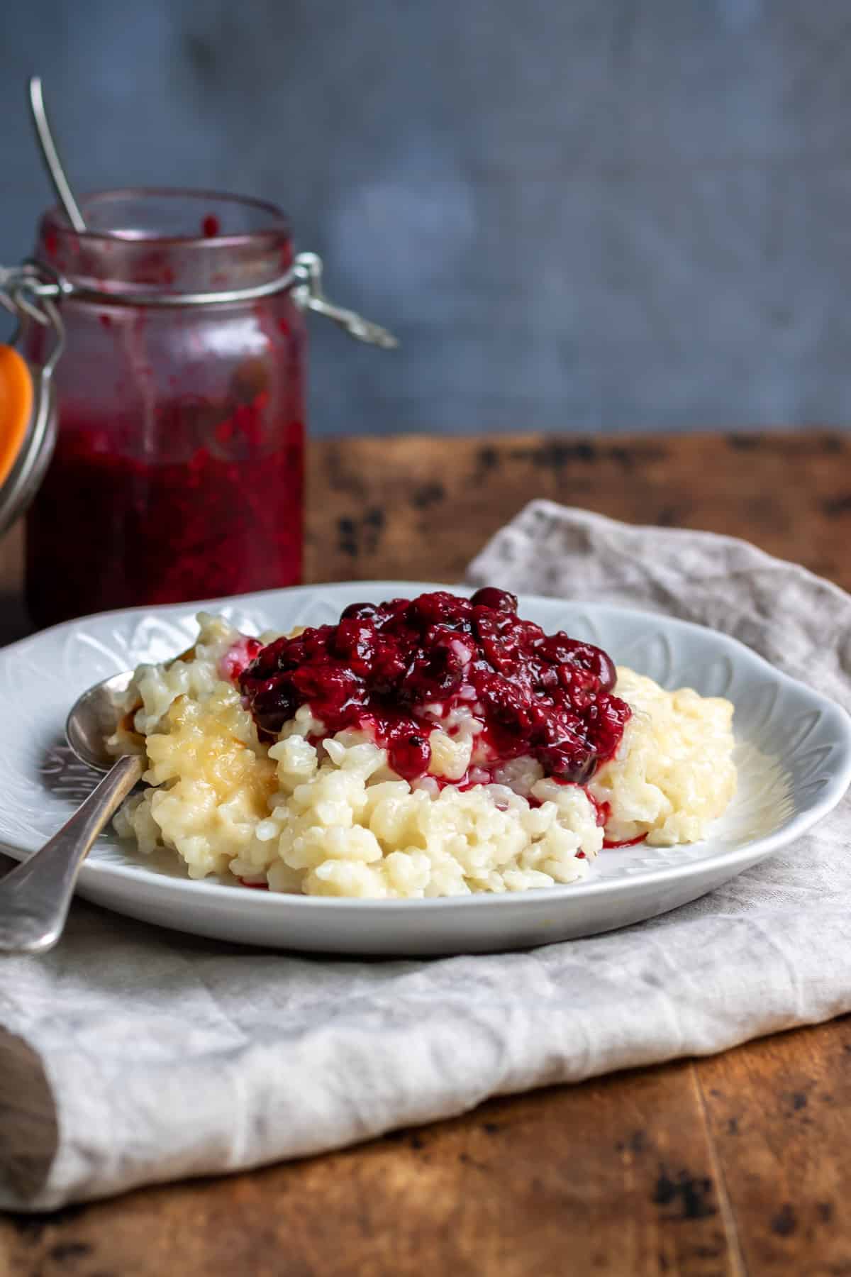 Plate of vegan rice pudding topped with berry sauce.