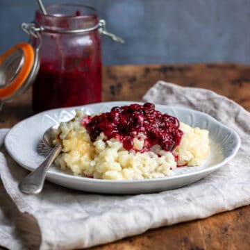Plate of vegan rice pudding topped with berry sauce.