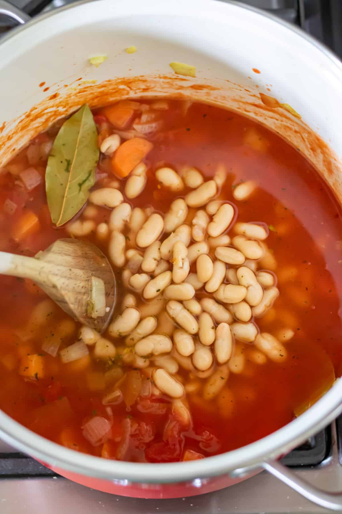 Beans, tomatoes and stock added to the pot.