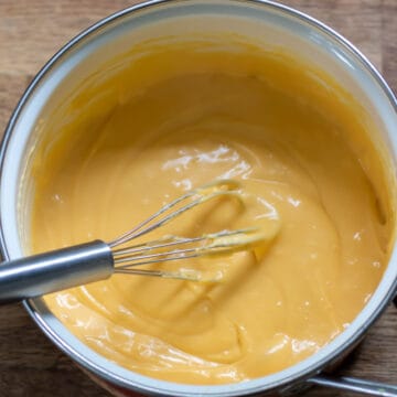 Whisk in a pot of cheese sauce.