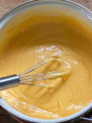 Whisk in a pot of cheese sauce.