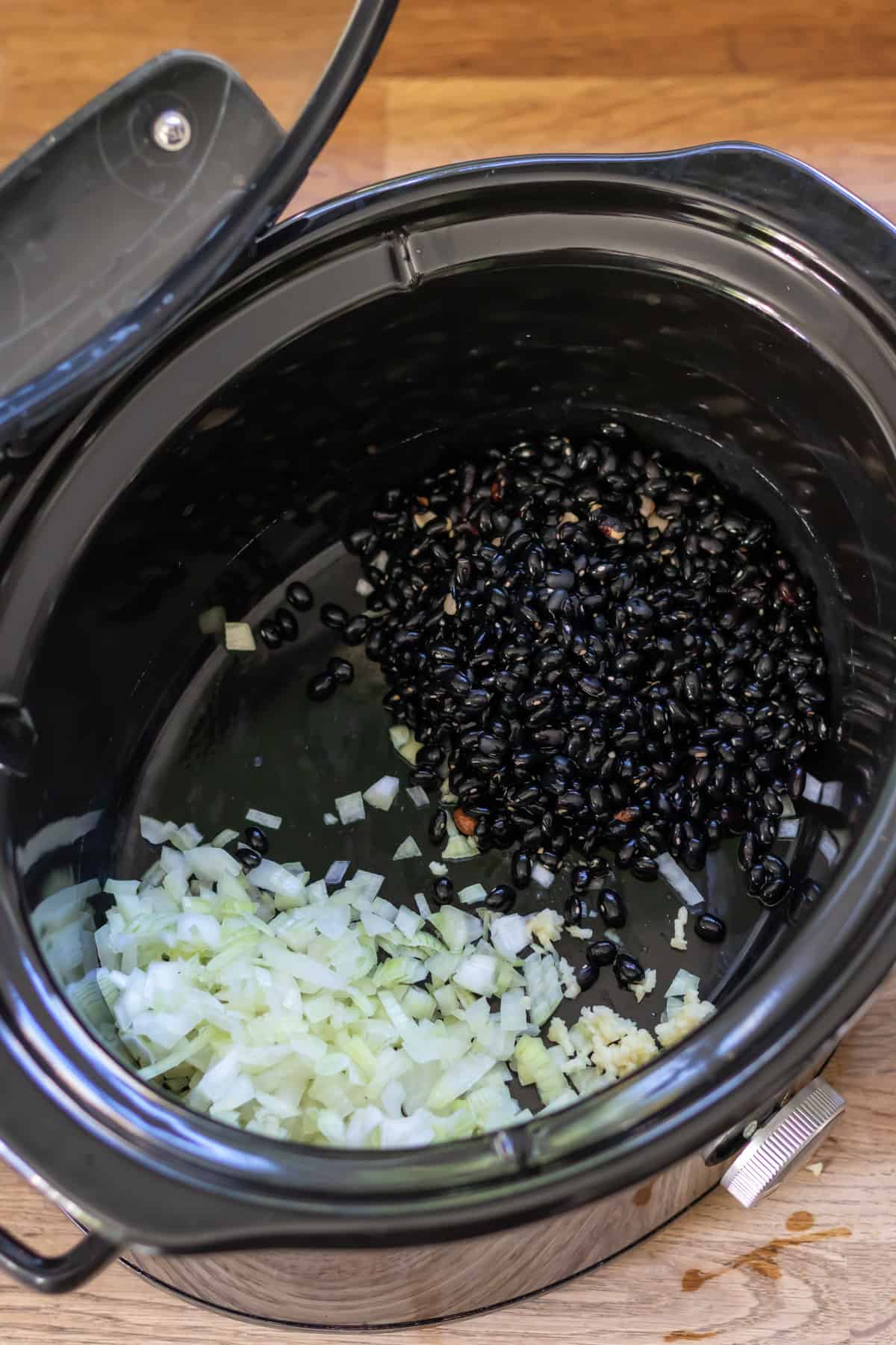 Black beans and onion in a slow cooker.
