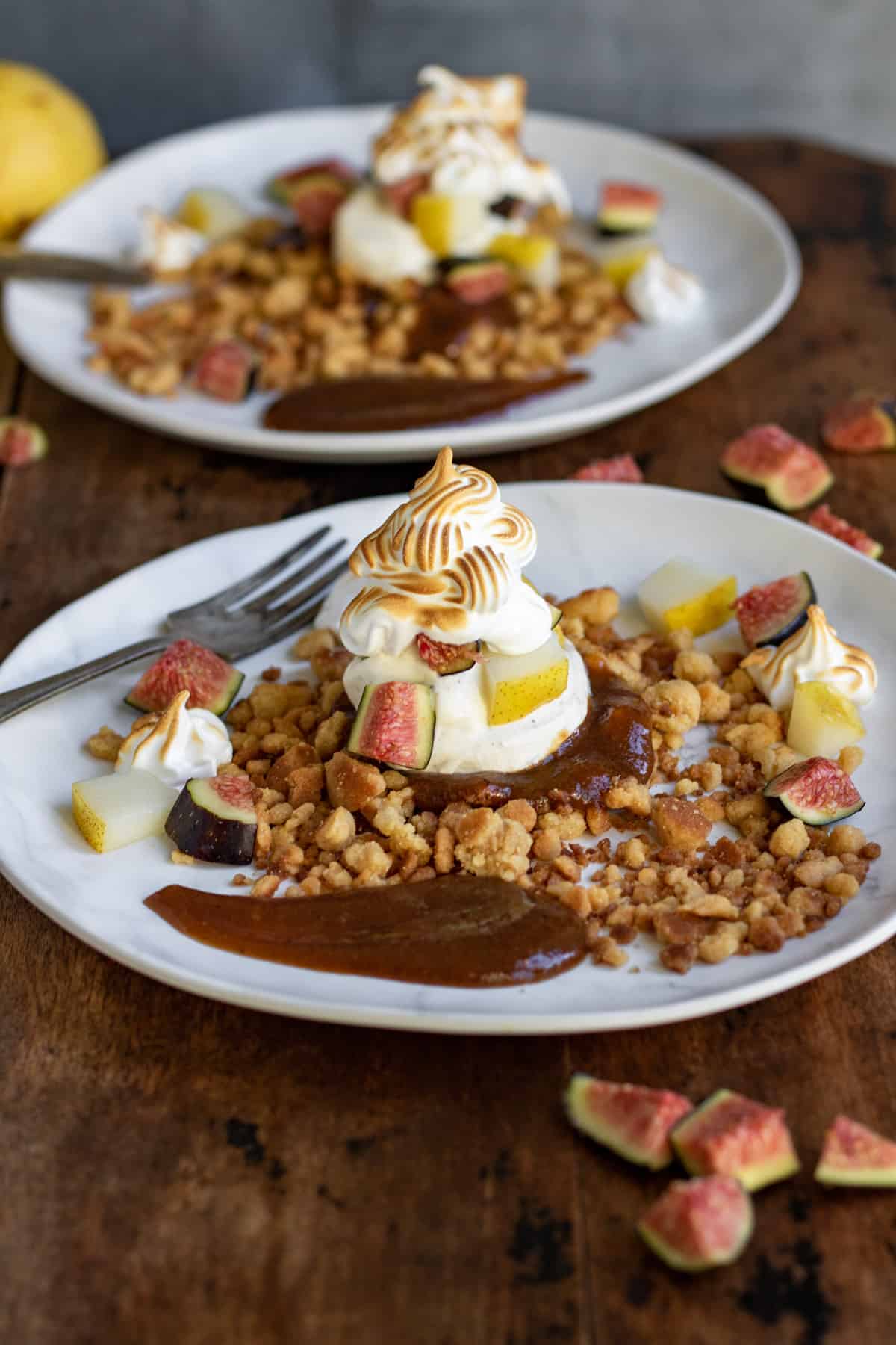 Crumble, cream, coulis, figs, pears and meringue all piled on a plate.