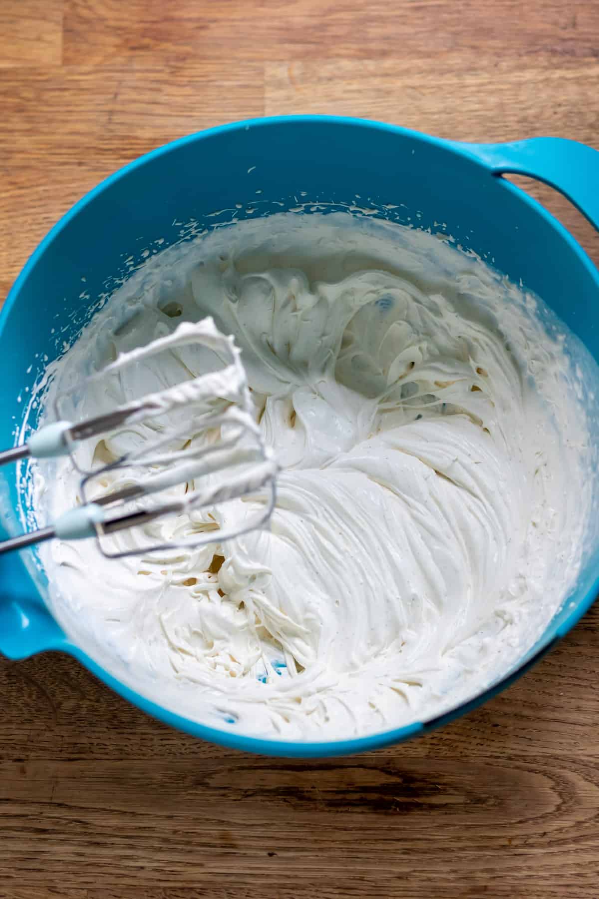 Whipping cardamom cream in a bowl.