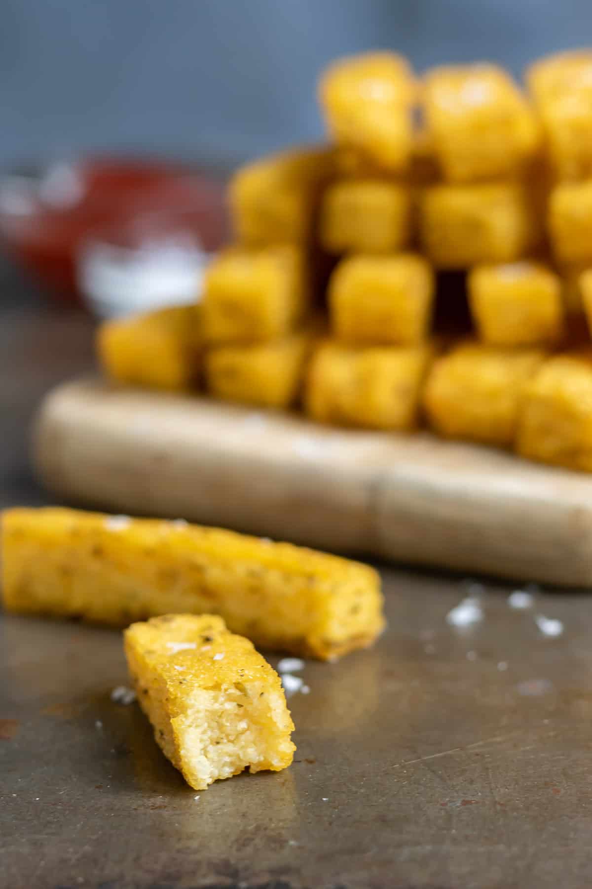 A polenta fry with a bite out.