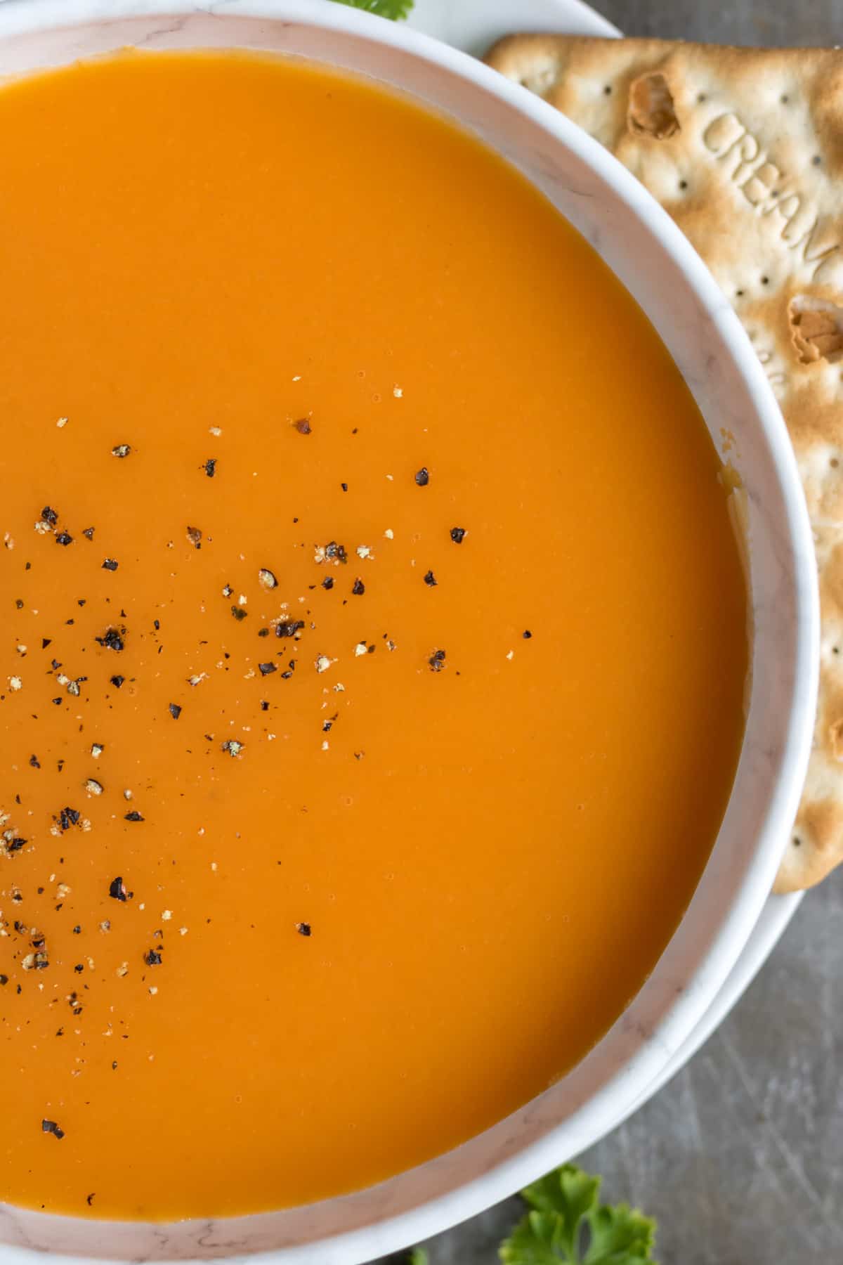 Close up of carrot ginger soup in a bowl.