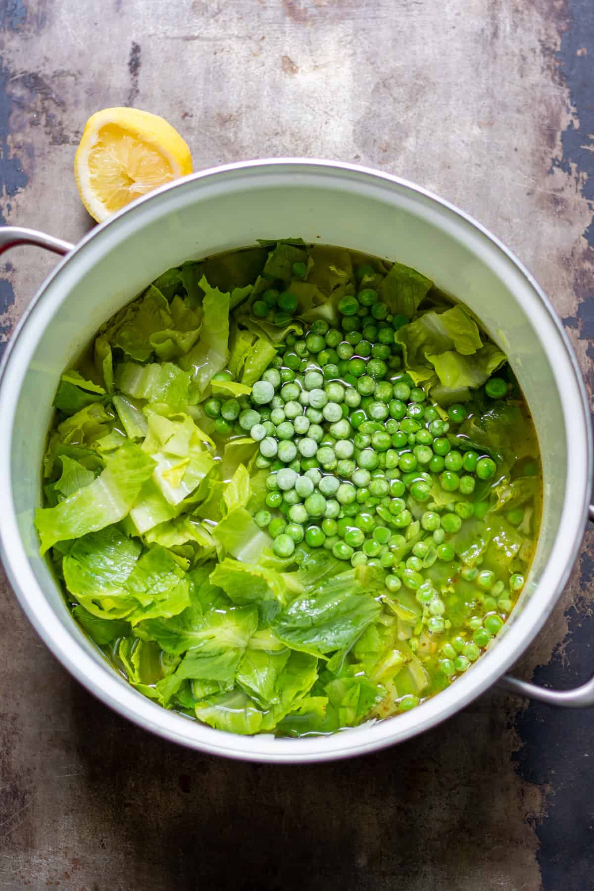 Adding frozen peas to the pot.