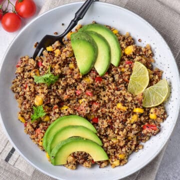 Slices of avocado on a bowl of Mexican quinoa salad.