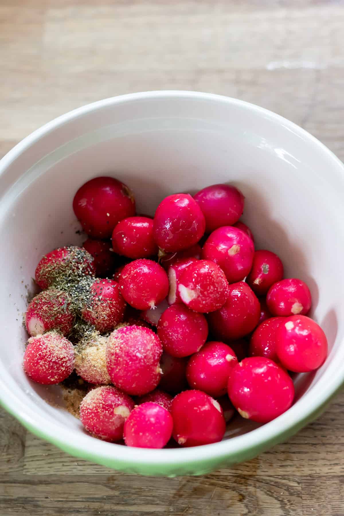 Radishes in a bowl with seasoning.