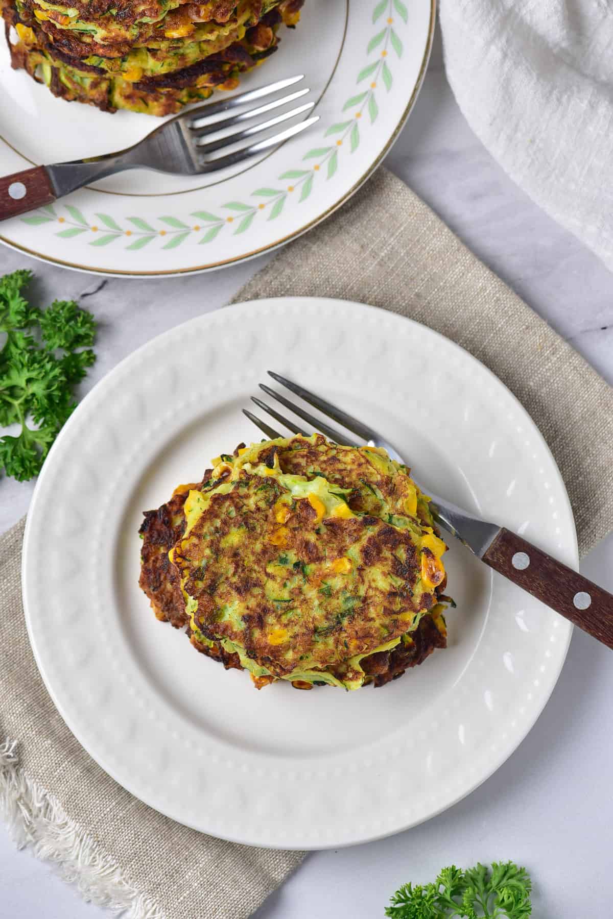A table with plates of zucchini fritters.