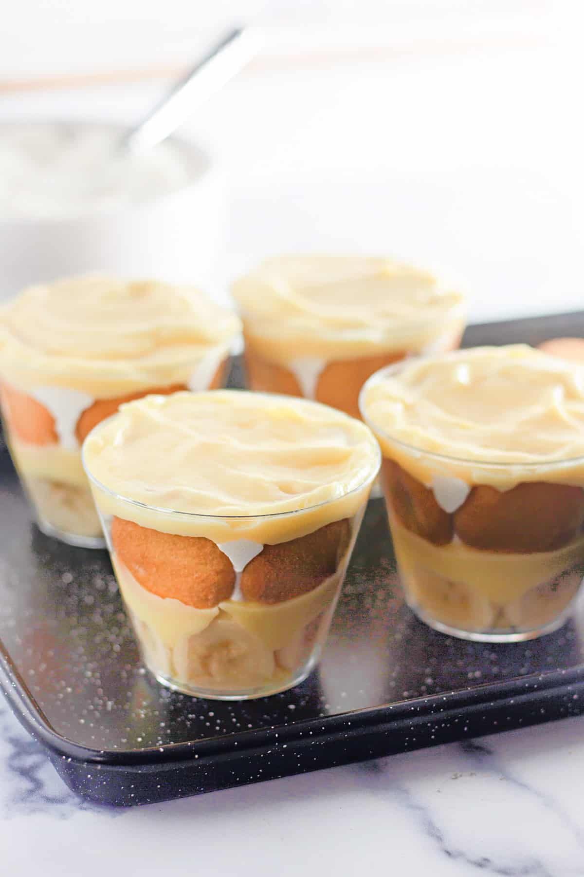 Tray of banana pudding cups being assembled.