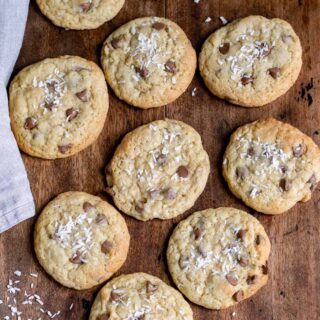 Rows of chocolate chip coconut cookies on a wooden table.