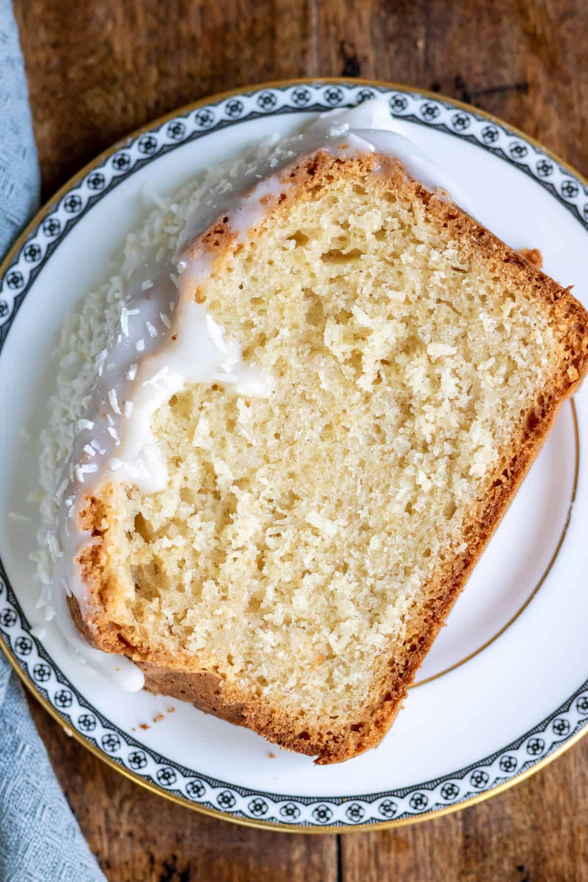 A slice of coconut bread with coconut glaze, on a plate.