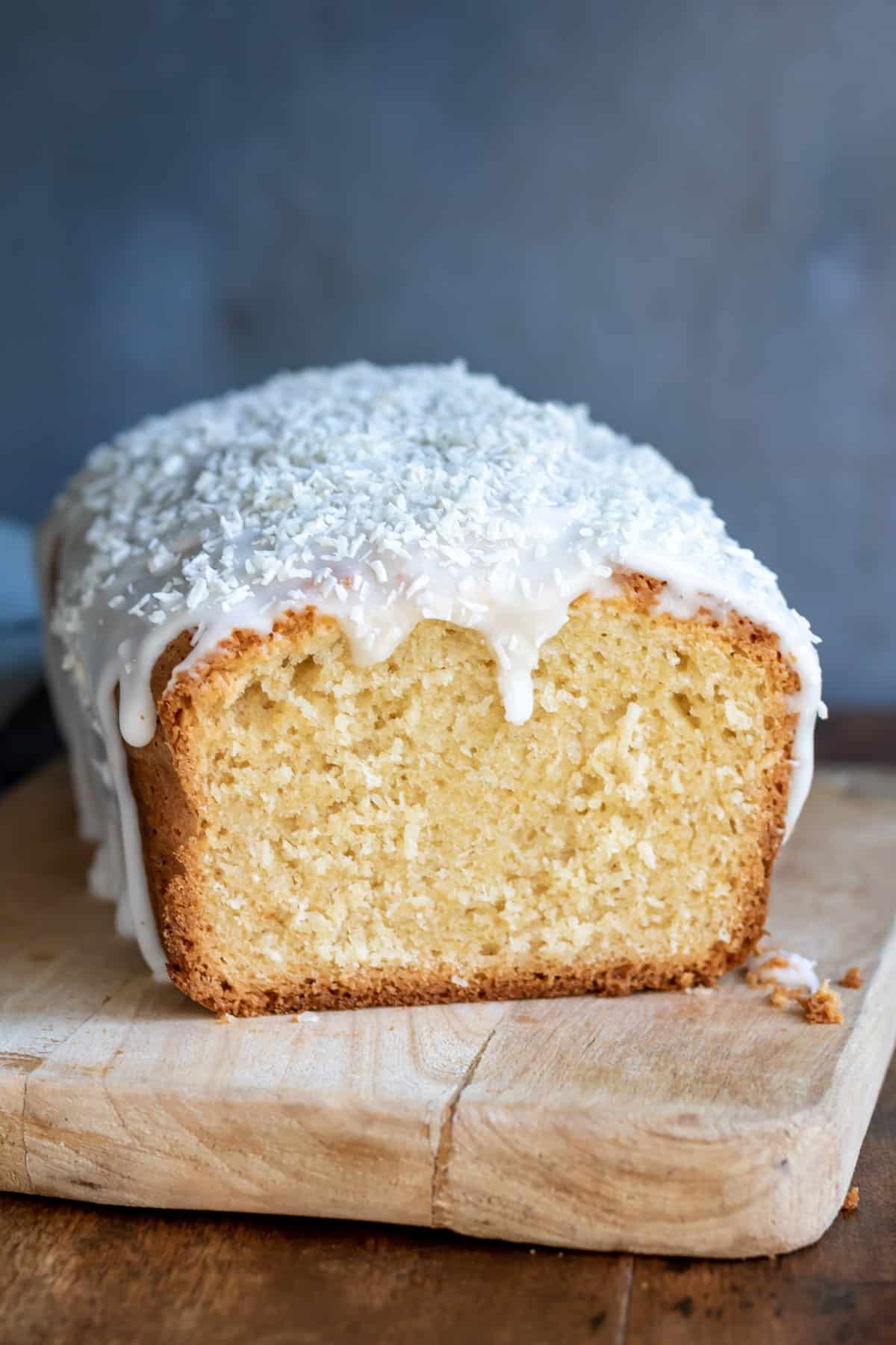 Close up of a coconut bread loaf with a slice cut out.