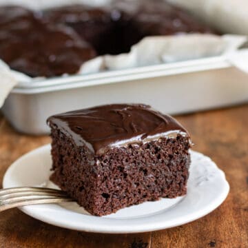 Square slice of chocolate wacky cake on a plate.