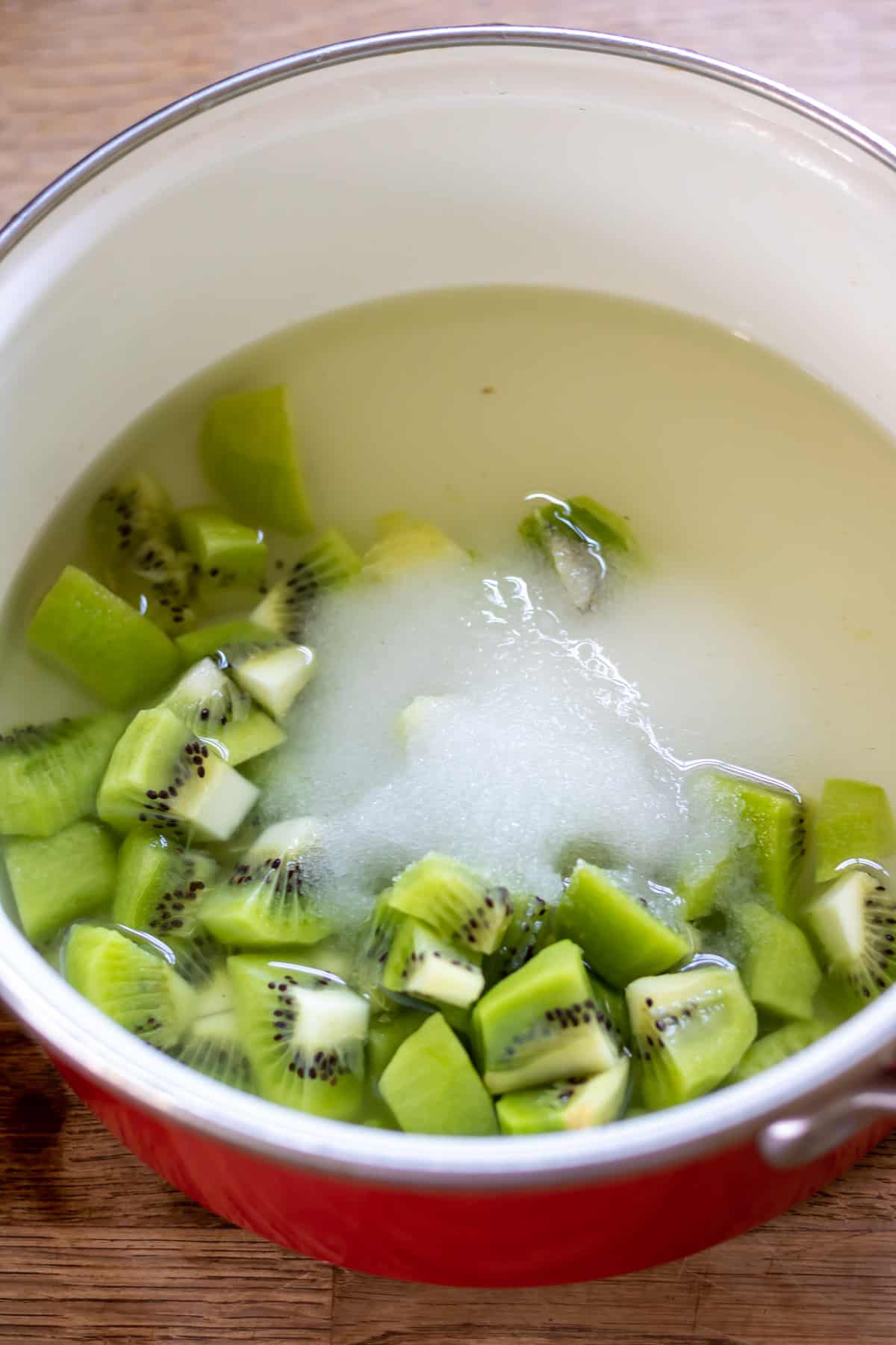 Kiwis, sugar and water in a pot.