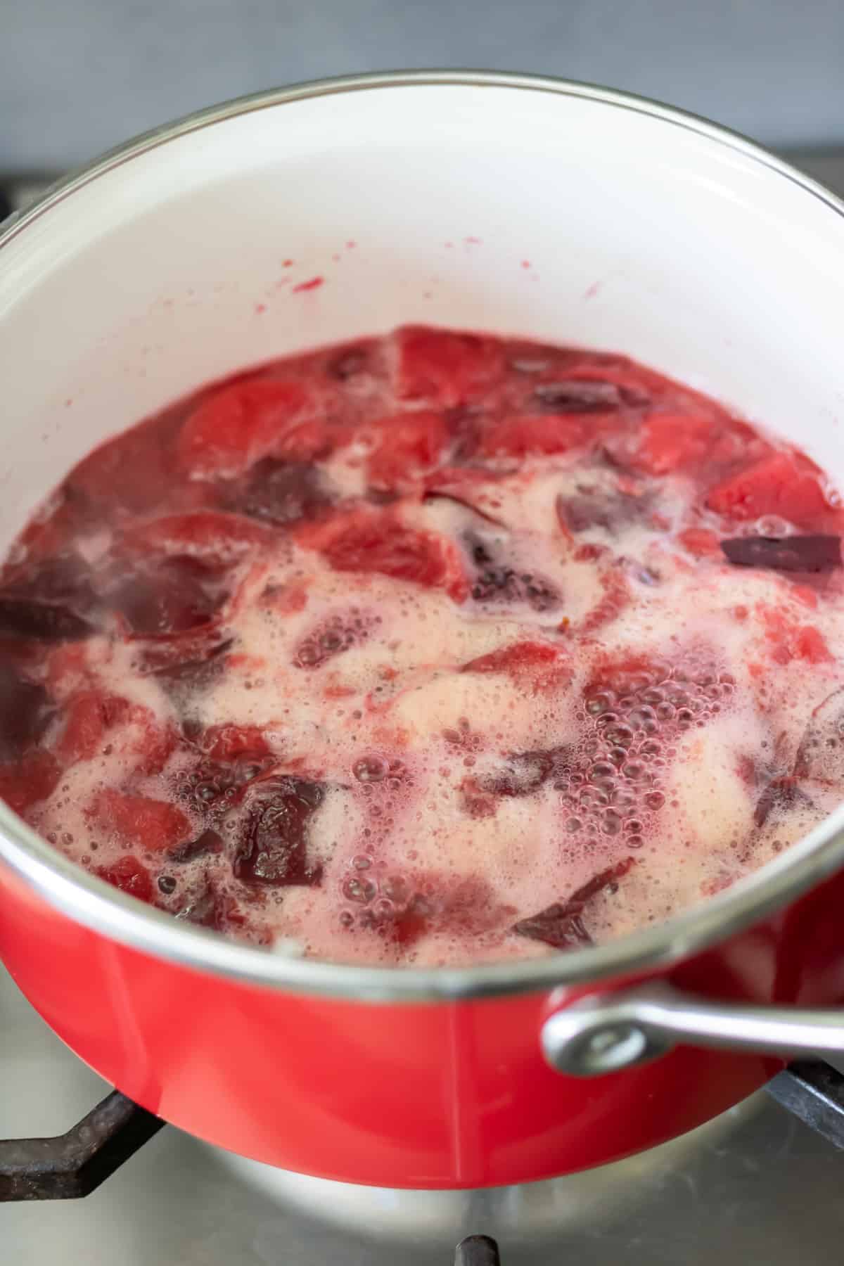 Boiling plums in sugar water.