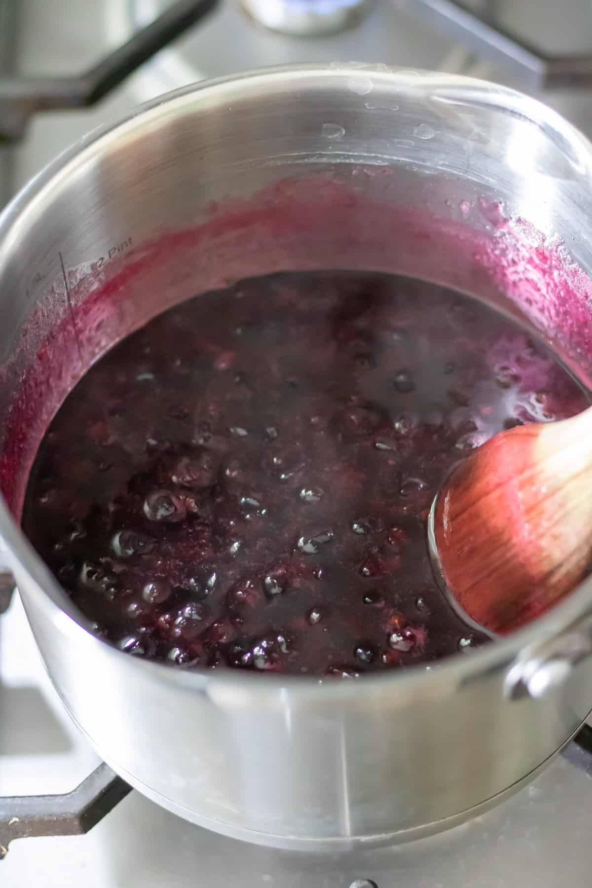 Cooked blackcurrant simple syrup in a pot.