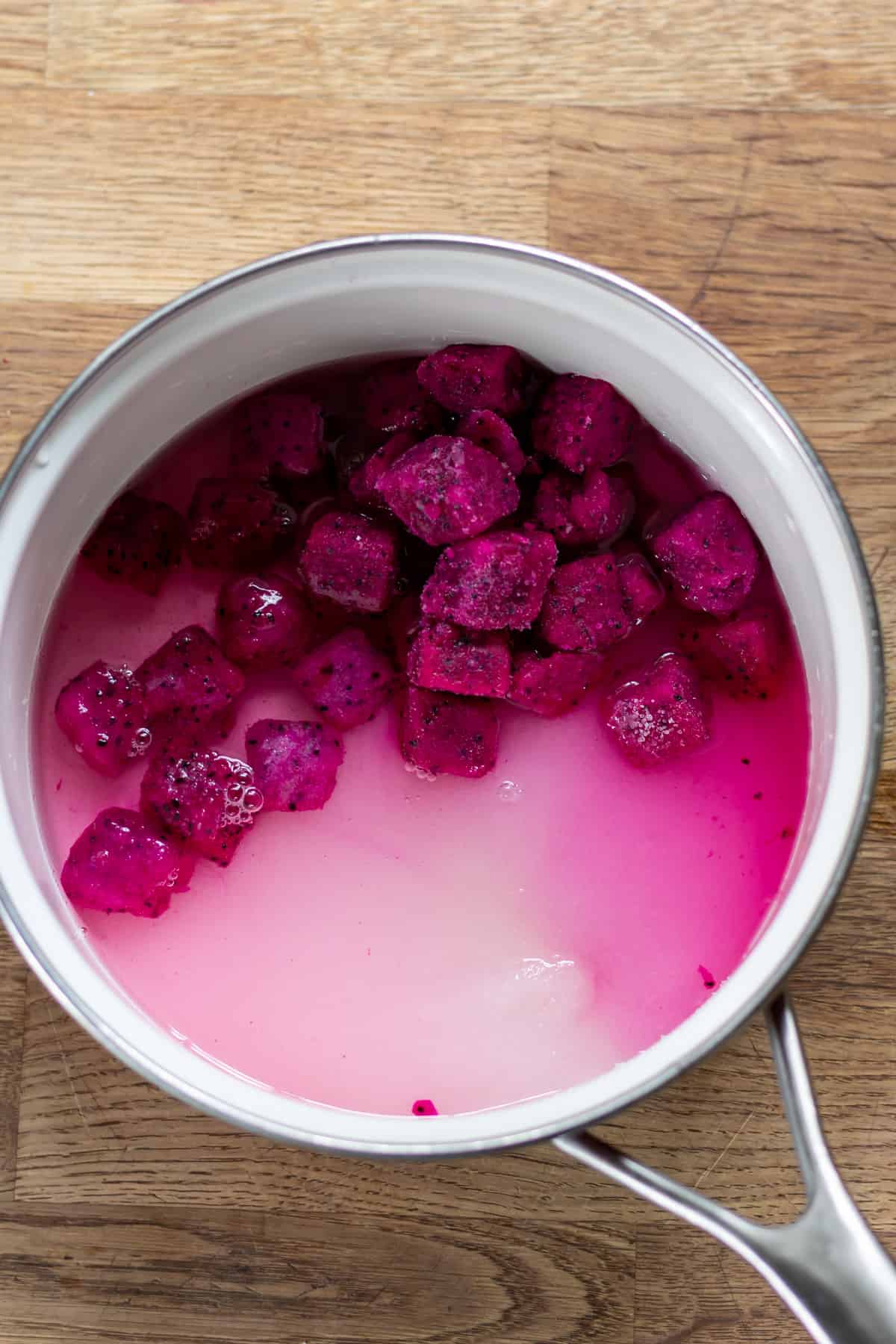 Pot with dragon fruit, sugar and water.