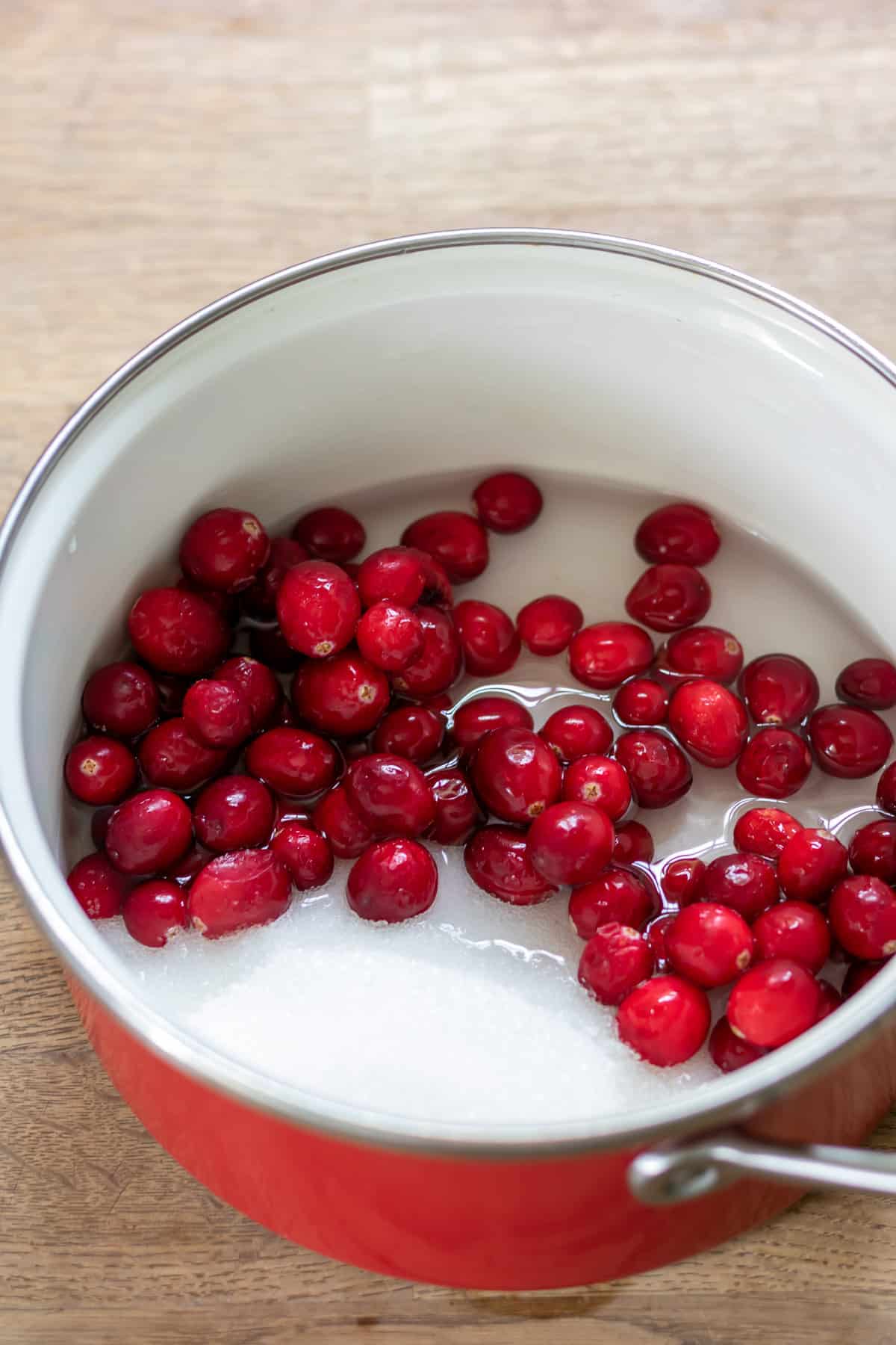 Cranberries, water and sugar in a pot.