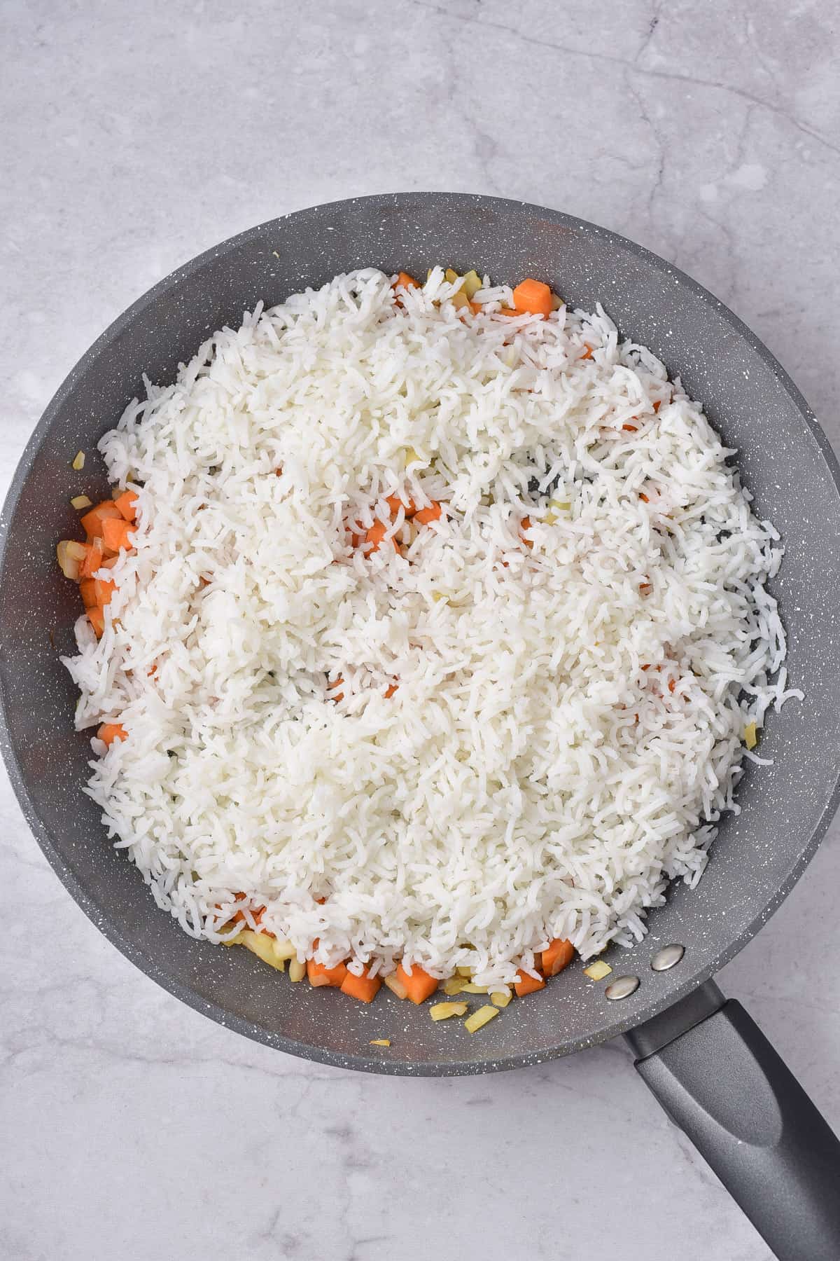 Adding cooked cold rice to the pan.