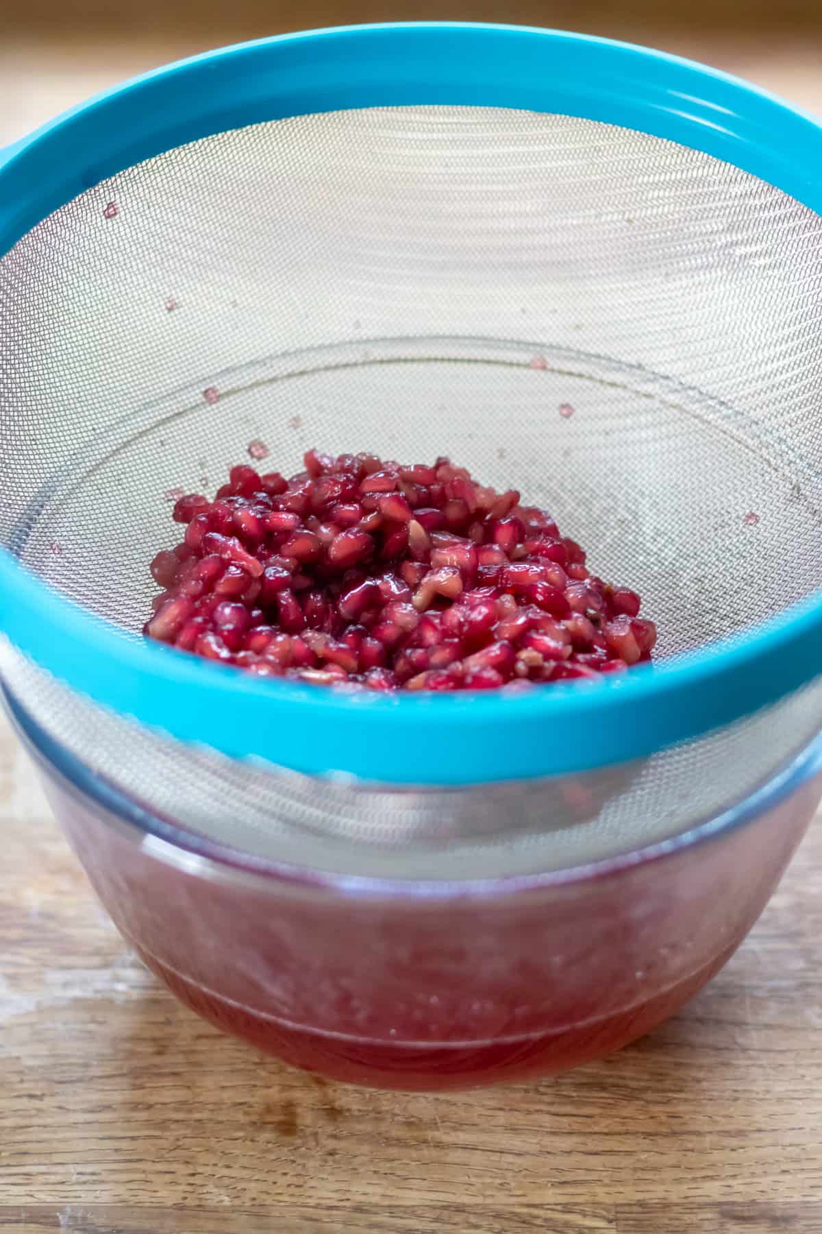 Straining the pomegranate syrup.