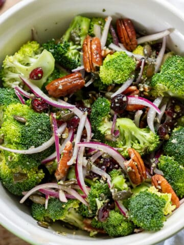 Bowl of broccoli cranberry salad with pecans and maple pumpkin seed dressing.