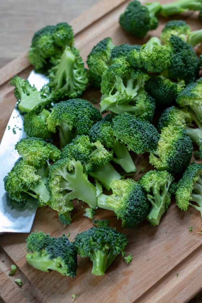 Chopping raw broccoli florets.