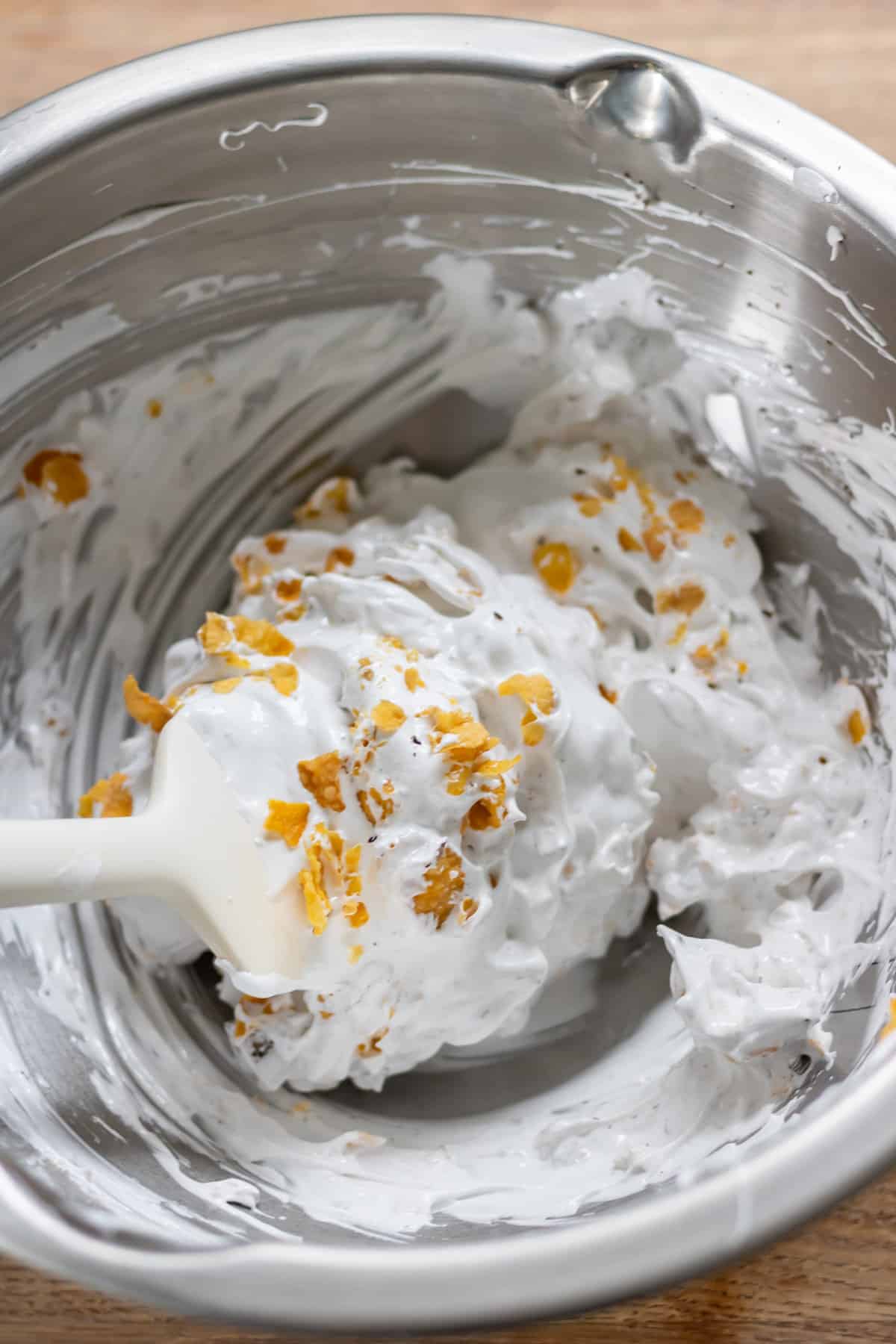 Mixing the cornflakes and chocolate into the meringue.