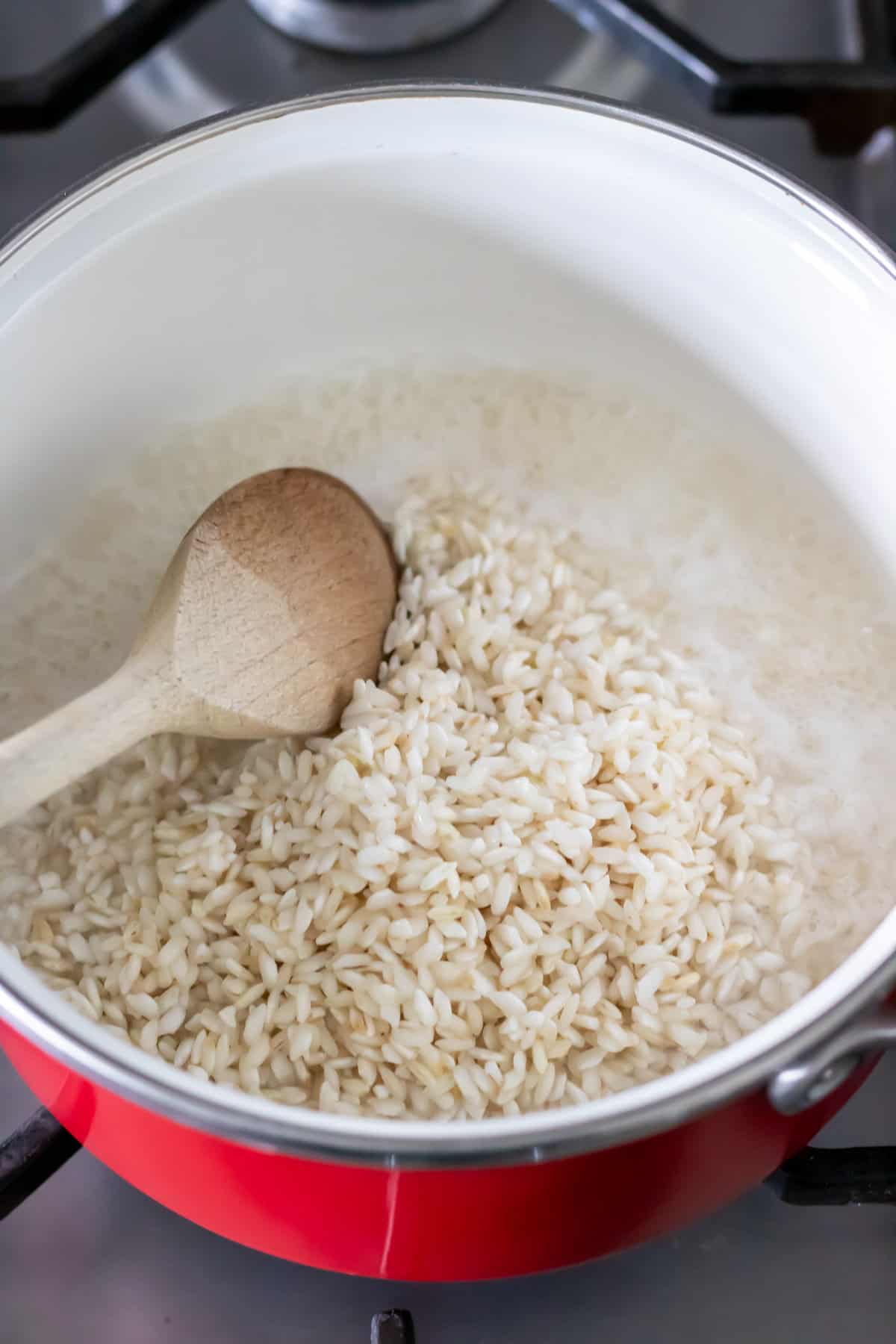 Stirring the rice and water in a pot.