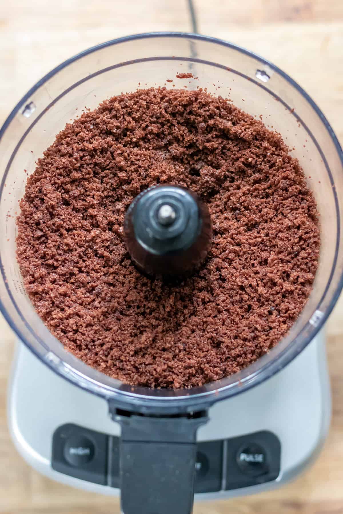 Cake mixed into crumbs in a food processor.
