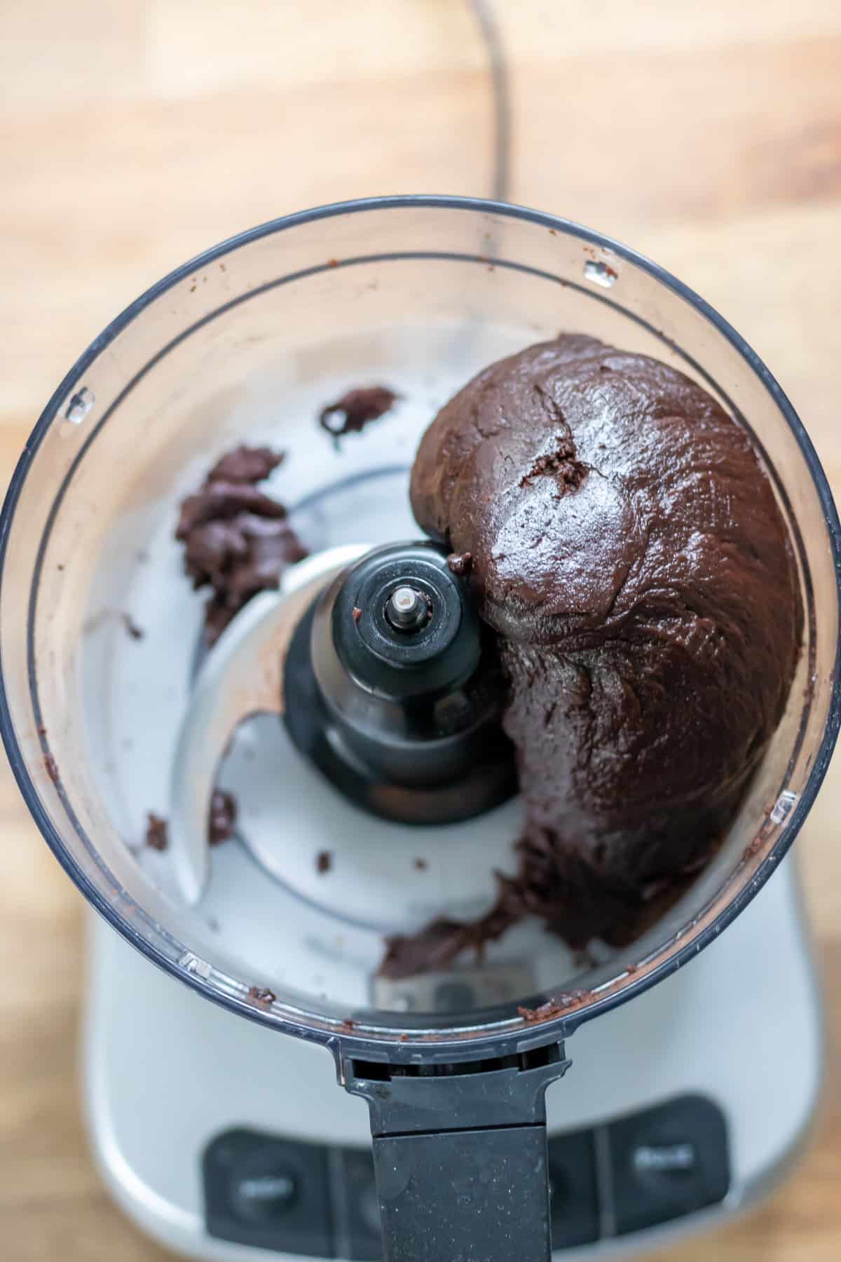 The rum ball dough mixed in a food processor into a thick paste ball.