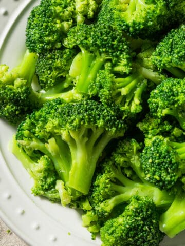 Close up of a plate of blanched broccoli.