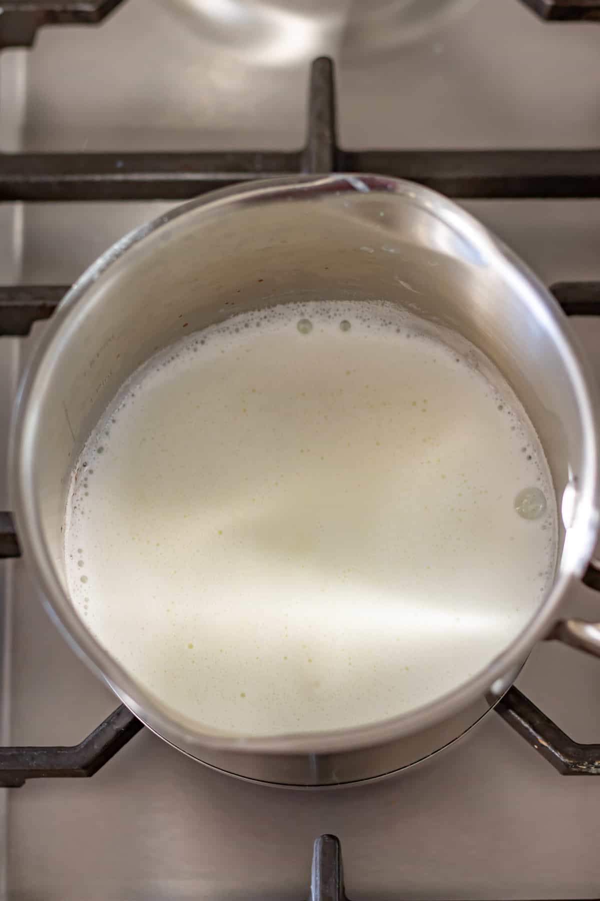Hot milk and water in a pot on the stove.