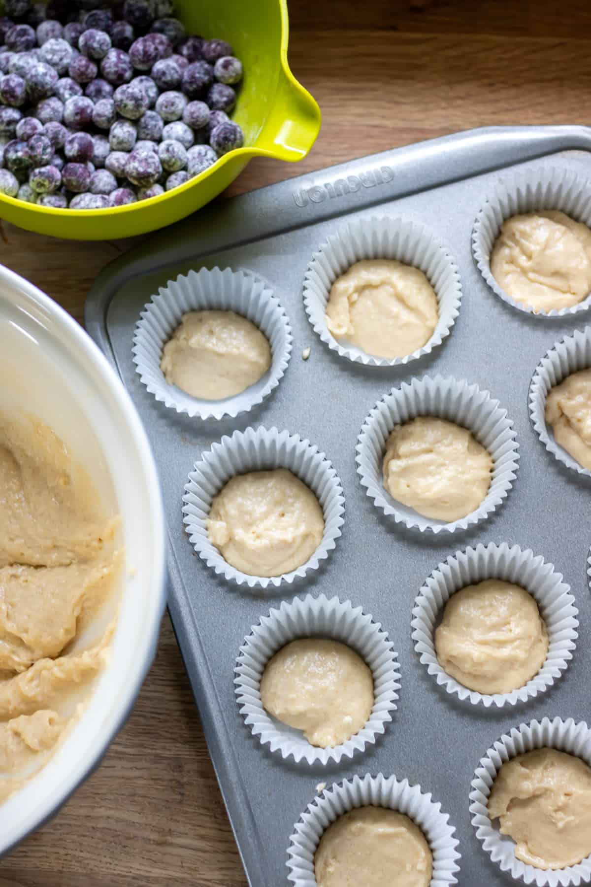 A little batter put into the muffin cases, before mixing the blueberries in, to prevent them from sinking.