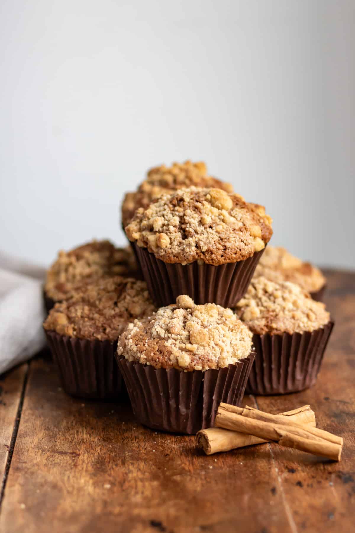 A stack of cinnamon muffins on a wooden table.