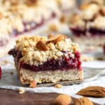 Close up of a piece of cherry bars, with streusel crumble topping and almonds.