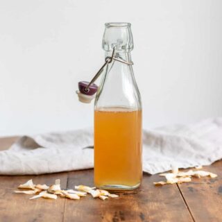 Bottle of toasted coconut syrup on a wooden table.