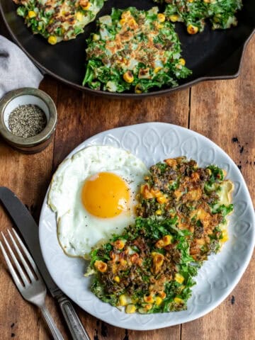 Looking down at a plate of kale fritters and a fried egg.