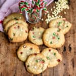 A pile of white chocolate candy cane cookies on a wooden table.