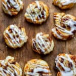 Wooden table with lots of mincemeat puff pastry swirls.