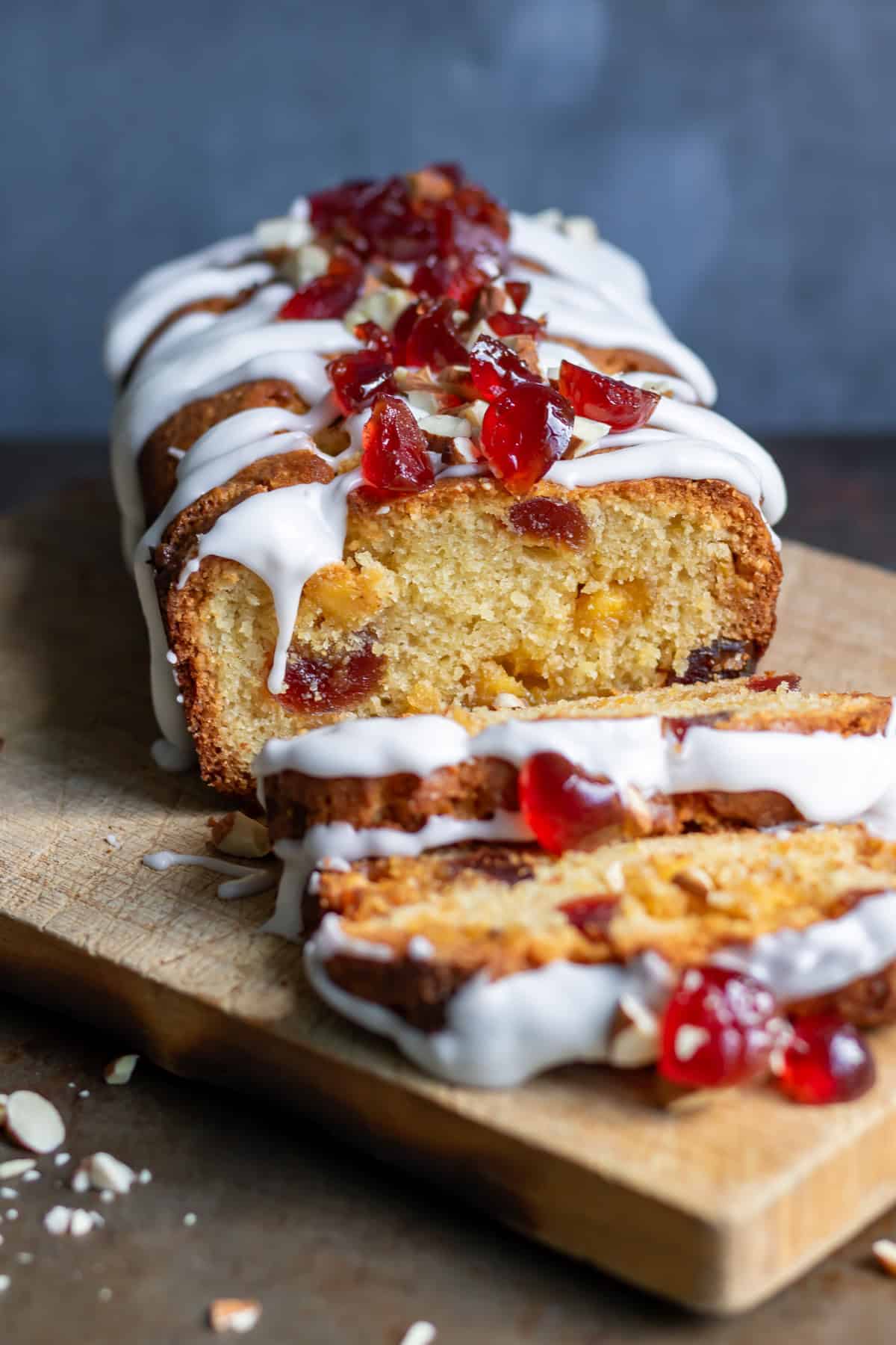 Front view of a sliced cherry marzipan cake.