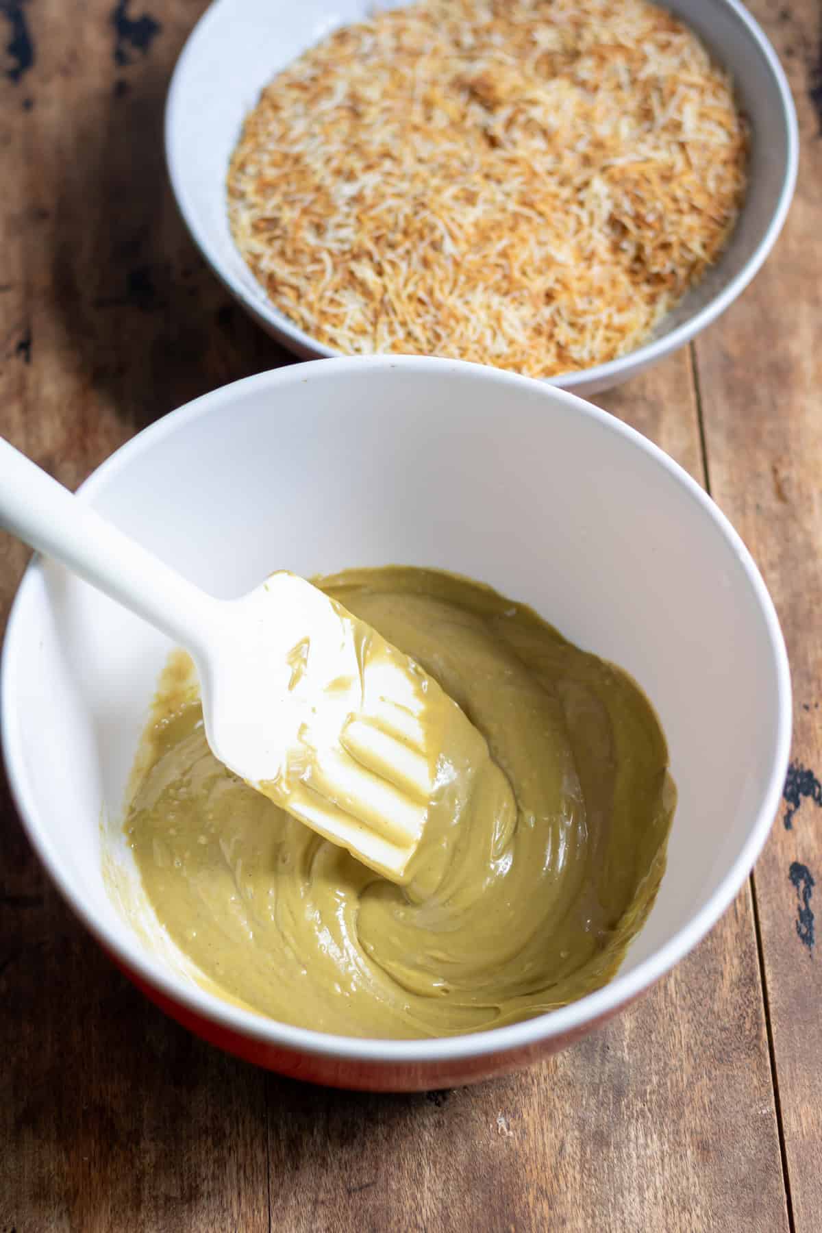 Mixing the pistachio creme, tahini and salt in a bowl.